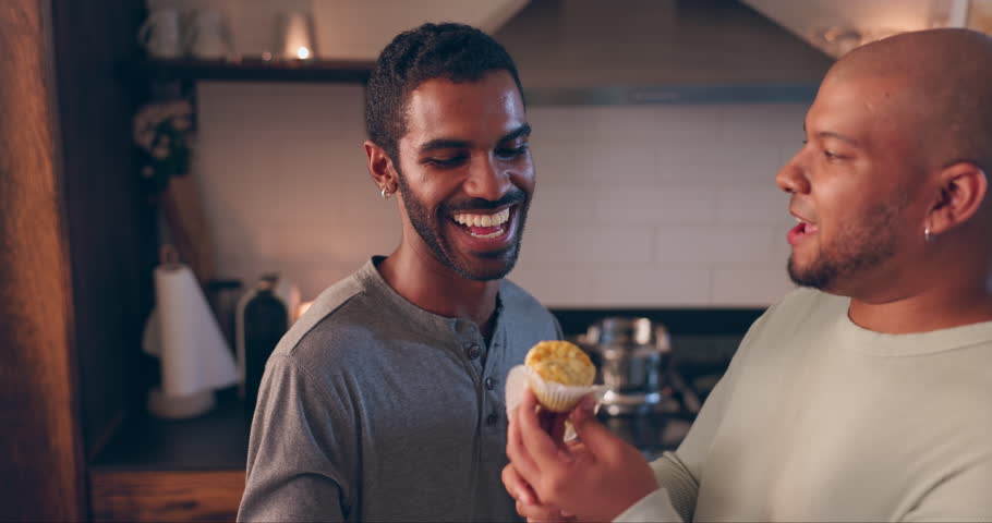 Eating, love and young gay couple in the kitchen for valentines day date night together at home. Happy, romance and lgbtq men in relationship taste food, bonding and talking in modern apartment.
