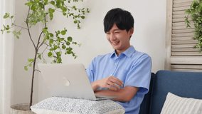 Asian man watching the laptop in the living room