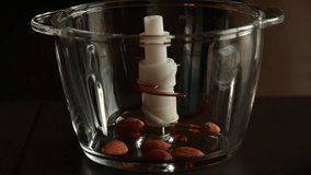 pouring almonds in a food chopper close-up