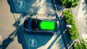 Charge station for electric cars. Electric car charger. Zero emission vehicle on EV only charging station. Aerial view 4K. Battery icon indication of charging.  - Powered by Shutterstock - Get 15% off with code: PIKWIZARD15