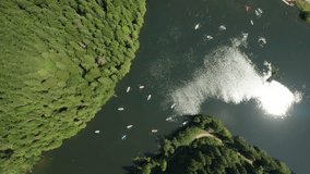 4K aerial video with zoom in movement over a lot of tourist boats on a lake in the middle of the mountains.