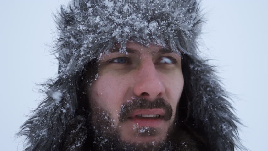 bearded man in earflaps and snow