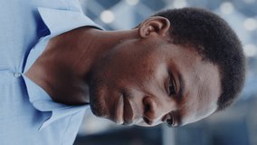 Vertical Video. Portrait of the Happy African American Guy Standing Outside. Smiling Young Businessman Outdoors in the Business District Looking at the Camera. People and Business Concept