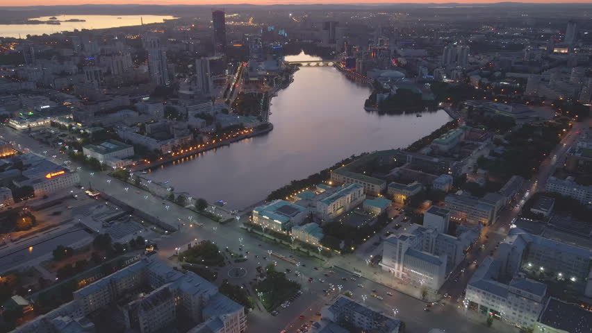 Yekaterinburg at dusk river Iset Metropolis amidst Urals modernity meets history. Metropolis canvas of high-rise buildings and cultural depth From above city