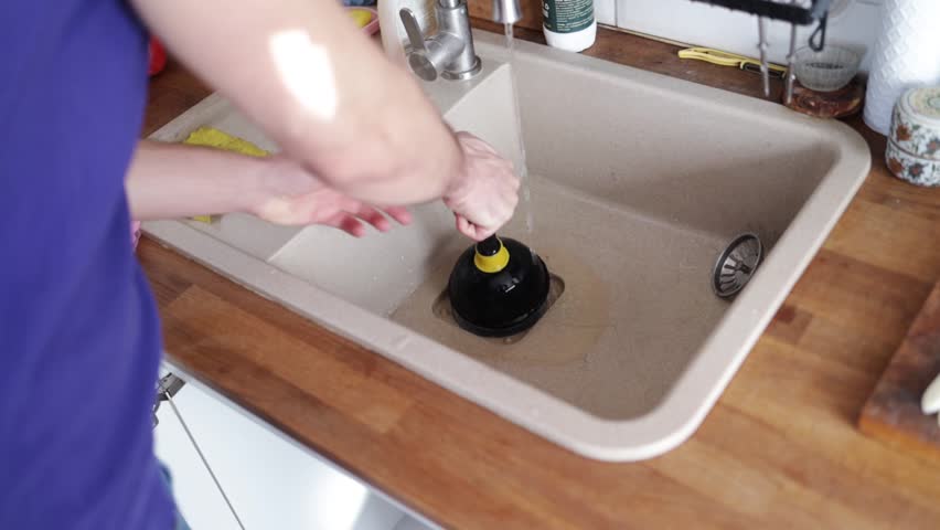 Unblocking the kitchen sink with vacuum apparatus, a person unblocks the sink with a vacuum Royalty-Free Stock Footage #3419022465
