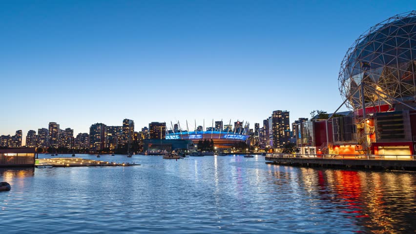A 4k long exposure time lapse during blue hour of the Vancouver Skyline from False Creek with the Science World Building and the BC Place Stadium illuminated.