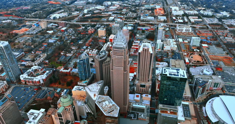 Modern urban panorama of Charlotte, North Carolina, US. Drone flight above the downtown of the city with mighty skyscrapers and low-rise buildings around.