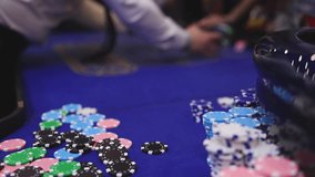 Vibrant casino table with roulette in motion, with casino chips, tokens, the hand of croupier, dollar money and a group of gambling rich people playing bet, blue poker table and deck of cards - Powered by Shutterstock - Get 15% off with code: PIKWIZARD15