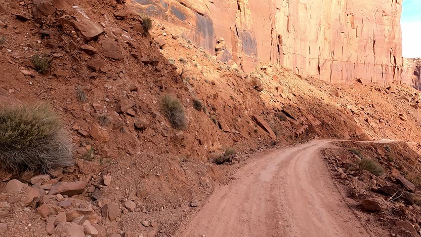 Driver Seat POV. Discover the hidden treasures of Utah’s Shafer Trail as you journey through steep dangerous shelf roads and rugged terrain on an unforgettable off-road adventure. Royalty-Free Stock Footage #3419183349