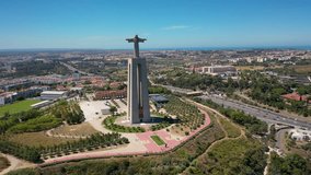 Aerial 4K video from drone to Sanctuary of Christ the King in Portuguese Santuario de Cristo Rei-Monument in Lisbon,Portugal,Europe.Catholic Statue with Jesus Christ in Almada near 25 de Abril bridge 