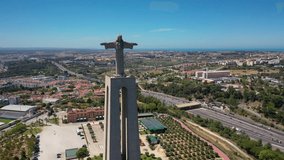 Aerial 4K video from drone to Sanctuary of Christ the King in Portuguese Santuario de Cristo Rei-Monument in Lisbon,Portugal,Europe.Catholic Statue with Jesus Christ in Almada near 25 de Abril bridge 