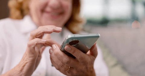 Hands, mature woman and smartphone with internet, typing or connection in a lounge. Pensioner, apartment or senior person with cellphone, mobile user or social media with contact, home or digital app Stock Video