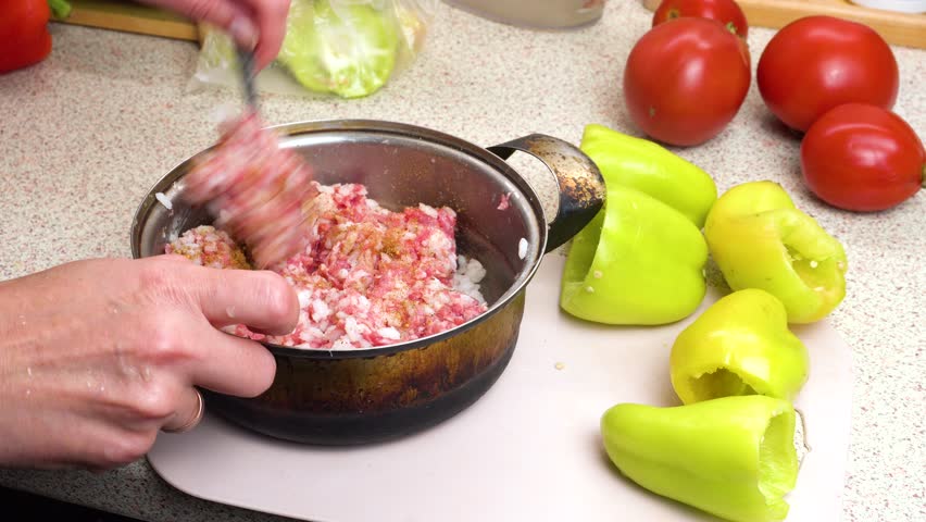 Preparation of minced meat for filling stewed stuffed sweet bell peppers. Pepper the minced meat. Step-by-step cooking video recipe. Culinary master class on home cooking.
 Royalty-Free Stock Footage #3419289175