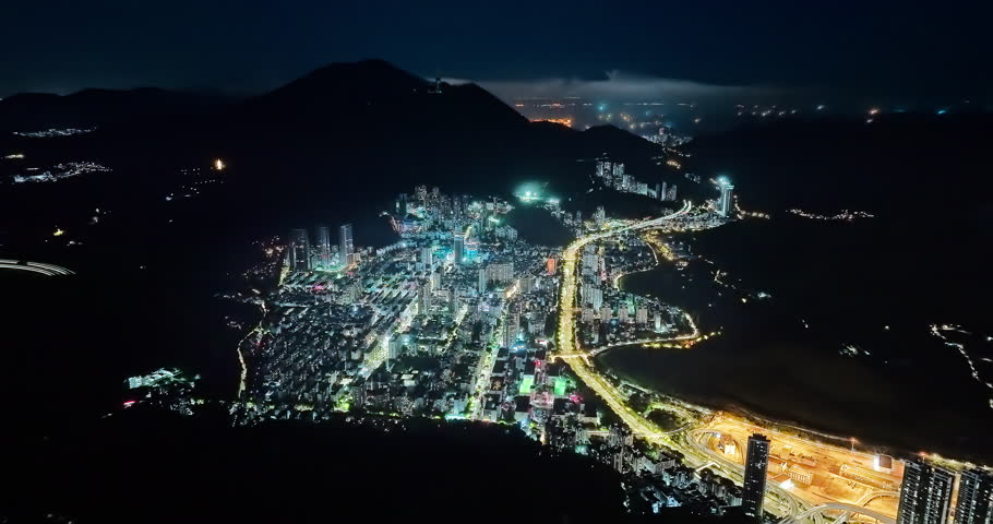 Aerial forward shot of Shenzhen financial district skyline and streets at night