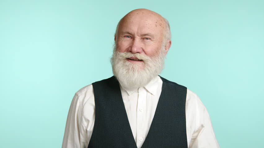 An engaging elderly man greets with a wave, his sparkling eyes and open expression convey warmth. Dressed smartly in a vest and shirt, set against a serene blue background. Camera 8K RAW. 
