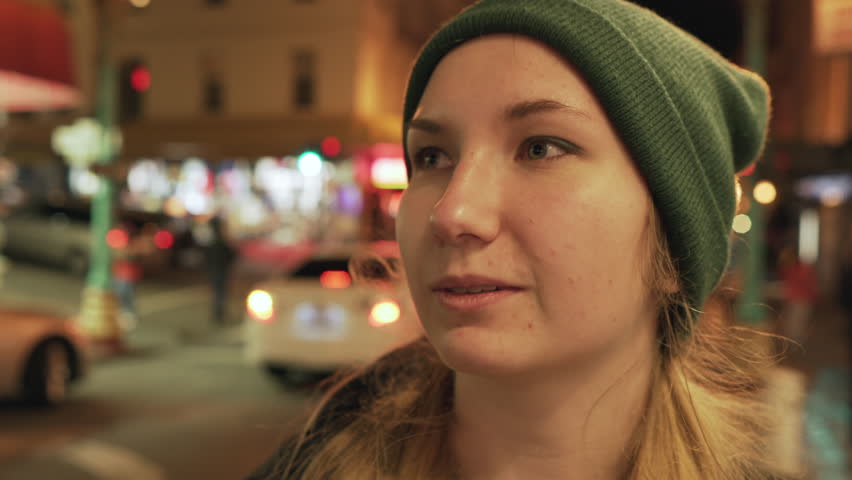 gimbal shot of teen girl standing on street of Chinatown in San Francisco at night