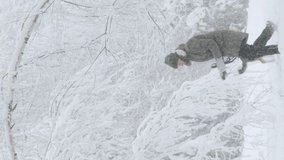 Young Beautiful Caucasian Girl Woman Dressed In Jacket Playing Wiht Puppy Of Mixed Breed Dog In Winter Forest In Snowy Day. Slow Motion Slo-mo Video.
