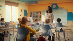 Group of Tech-Savvy Primary School Children Working on Their Laptop and Tablet Computers in Class. Young Female Teacher Educating Kids on Internet Safety, Basic Programming Languages and Formulas - Powered by Shutterstock - Get 15% off with code: PIKWIZARD15
