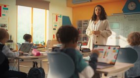 Excited Happy Teacher Explaining a Math Lesson to a Classroom Full of Bright Diverse Children in Primary School. Little Black Boy Browsing a Presentation on a Laptop Computer - Powered by Shutterstock - Get 15% off with code: PIKWIZARD15