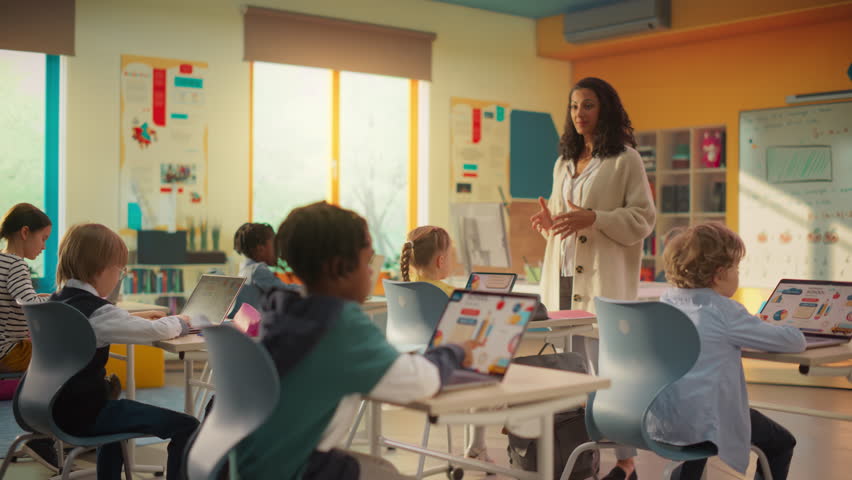 Class of Young Multiethnic Children Using Laptop Computers while Studying Math and Geometry in Grade School. Happy Female Teacher Explains Shapes and Measurements to Smart Boys and Girls - Powered by Shutterstock - Get 15% off with code: PIKWIZARD15