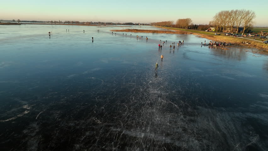 Ice skating on the floodplains of the Zwarte Water near Hasselt in nature seen from above during a cold winter day in The Netherlands.
