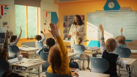Elementary Classroom with Diverse Children Listening to the Teacher Asking a Question. Everyone Raising Hands in Order to Provide a Correct Answer. Bright Kids in School Learning Exact Sciences - Powered by Shutterstock - Get 15% off with code: PIKWIZARD15