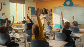 Excited Elementary School Teacher Asking a Diverse Class of Children a Mathematical Question. Smart Kids Raising Hands while Sitting Behind a Desks and Eager to Provide a Solution - Powered by Shutterstock - Get 15% off with code: PIKWIZARD15