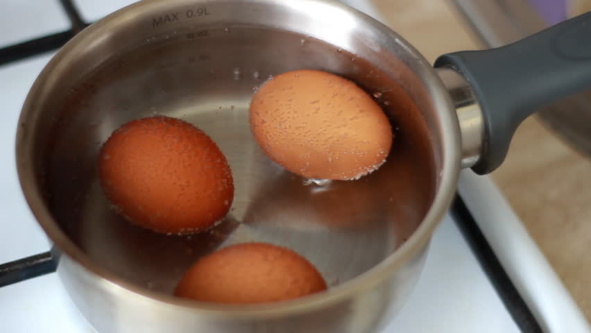 Eggs are boiled in a metal pan. Chicken eggs are boiled in boiling water in a saucepan. Royalty-Free Stock Footage #3419514283