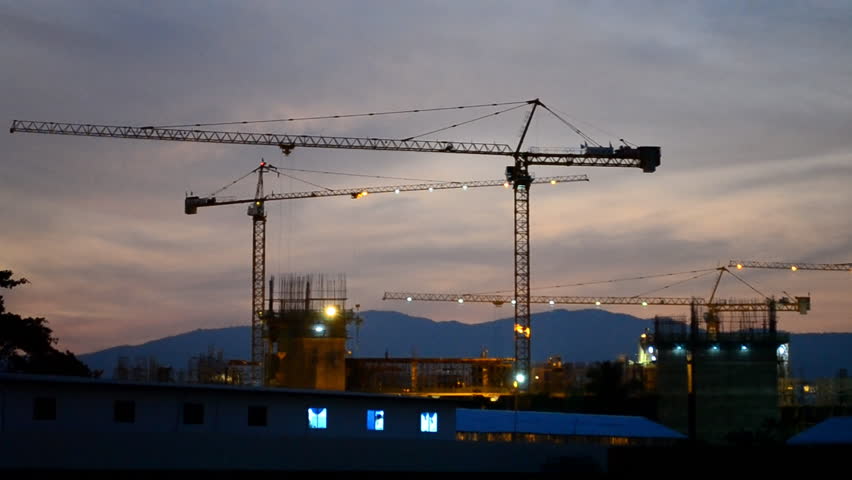 time lapse silhouette crane building and dusk time