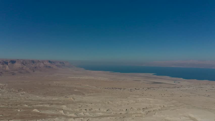 Aerial panoramic view of the Dead Sea and the ancient fortification Masada in the Southern District of Israel situated on top of an isolated rock plateau, eastern edge of the Judaean Desert, Israel