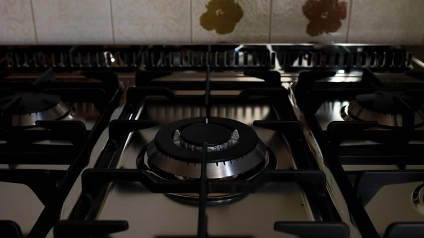 kitchen gas stove alight with flame coming out of it. Conceptual photo for gas, cost of bills, rising prices, heat and the environment. metal Ukraine, Russia, Europe. blu flame. united states. cook