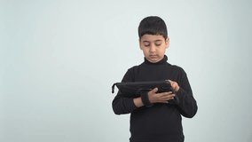 Video of an eight-year-old boy playing on a tablet and constantly winning, white background.
