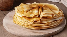 Thin pancakes on a wood plate. Homemade crepes, tasty food. Staple of yeast pancakes, traditional for Russian pancake week. High quality 4k footage