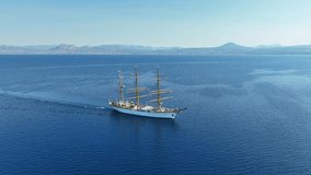 Aerial drone cinematic video of beautiful 3 mast barque or barc type classic sailing wooden boat cruising in Mediterranean deep blue sea - Powered by Shutterstock - Get 15% off with code: PIKWIZARD15