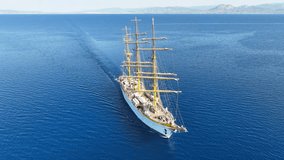 Aerial drone cinematic video of beautiful 3 mast barque or barc type classic sailing wooden boat cruising in Mediterranean deep blue sea - Powered by Shutterstock - Get 15% off with code: PIKWIZARD15