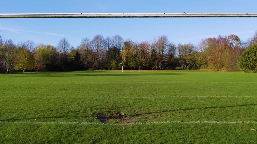 Empty grass Football Pitch drone. Zooming out slowly behind goal posts. Bridge, Canterbury, Kent, England Royalty-Free Stock Footage #3419690445