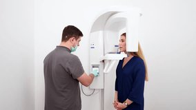 Male radiologist taking teeth x-ray of female patient using dental x-ray machine. Dentist adjusts scan projection by laser guide. Doctor doing digital x-ray tooth scan for woman in the dental clinic. - Powered by Shutterstock - Get 15% off with code: PIKWIZARD15