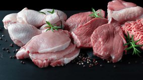 Different types of raw meat - beef, pork, lamb, chicken on a wooden board. High quality 4k footage