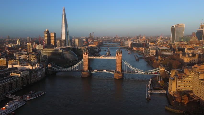 Drone shot captures Tower Bridge and the Thames River bathed in the golden light of sunrise, with the London skyline rising in the background.Golden hour, Camera 4K RAW.  Royalty-Free Stock Footage #3419844503