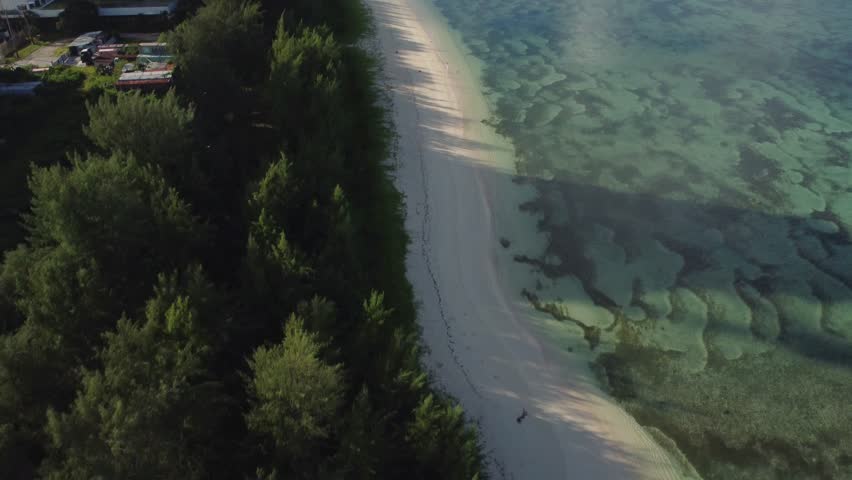 Tilt up drone shot of white sand coastline of Saipan, Northern Mariana Islands