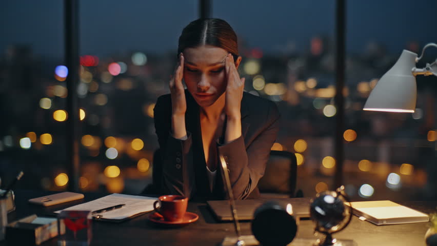Night worker massaging head rub temples at cityscape. Tired businesswoman work late brainstorming ideas in contemporary dark office. Stressed manager feeling headache fatigue thinking problem solution