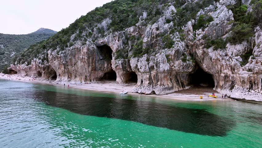Aerial view of the cliff with small caves in Cala Luna, beach in Sardinia.