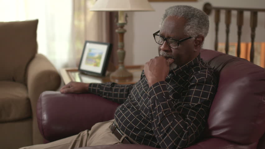 An elderly African American male sits in a chair, worried, stressed and thinking about a problem. Prores file. Royalty-Free Stock Footage #34198933
