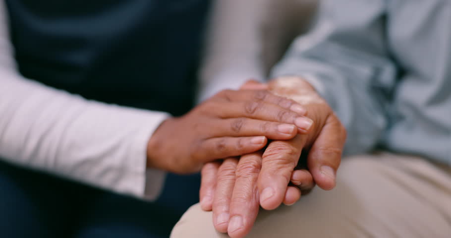 Holding hands, senior person and nurse with empathy, care or support in grief, mental health or anxiety in home. Caregiver, doctor and elderly patient with comfort, kindness and closeup in retirement