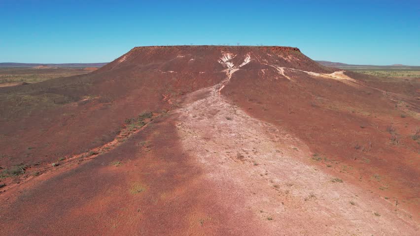 A flat topped outmain covered in red dirt and viens of salt found in the South Australian Outback 