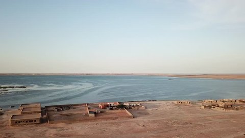 Aerial Drone View of Desert, Ocean Bay Constructions, Fences, Houses at Sunset. Dlog Panorama shot in Nouadhibou, Mauritania, West Africa.