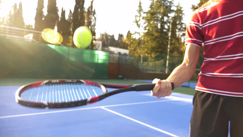 the man beats the tennis ball from the racket. close-up. Senior man playing tennis. 4k, slow motion