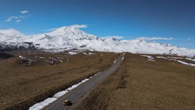 Scenic aerial view of a beautiful road in the mountains overlooking Europe's highest mountain Elbrus in the North Caucasus of Russia. High quality 4k footage