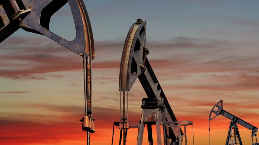 Oil Well Pump Jacks Extracting Crude Oil At Sunset. Fossil Fuel Energy. Oil Industry Equipment . CO2 Emission Intensity of Crude Oil Production.