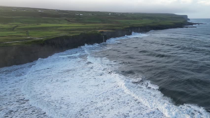 Aerial dolly shot towards a small waterfall on the Doolin cliffs, Ireland